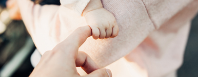 baby fist gripping mom's finger