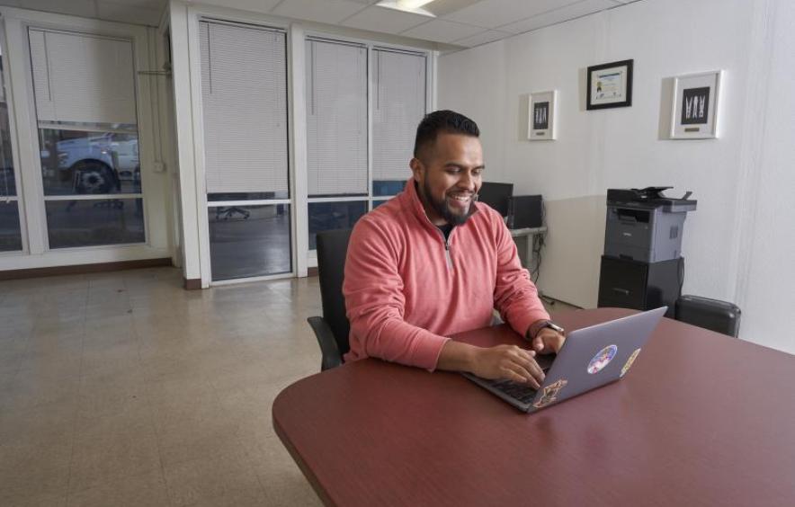 Photo of man smiling while on his laptop