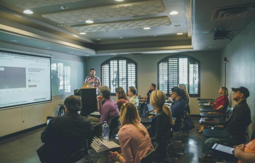 A professor is conducting class at a podium.