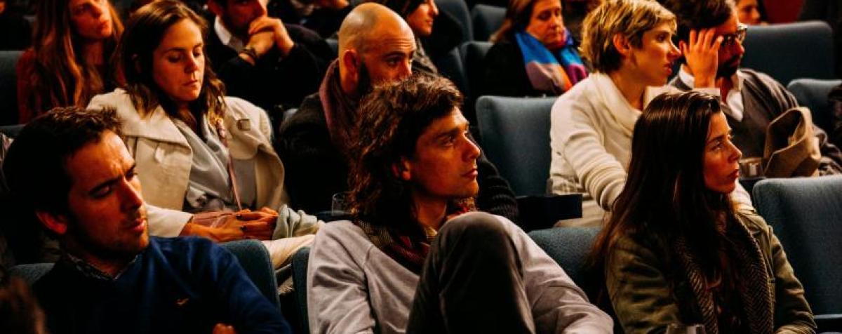 A group of students sitting in a lecture hall.